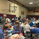 A picture of dentists and assistants working on patients at 2016 COMOM dental clinic