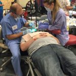 Dr. Albers and assistant place a filling on a patient at the 2016 COMOM Dental Clinic