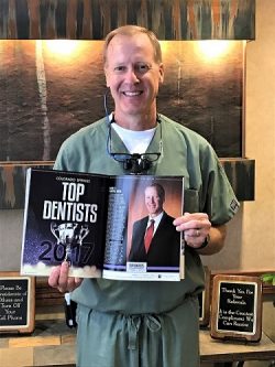 Dr-Albers-holds-magazine-showing-2017-top-dentist-designation